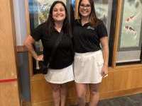 
                  Two people in black shorts and white skirts