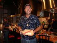 
                  Person in hat holding custom cutting board and chopsticks