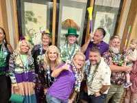 
                  Group in Mardi Gras attire posing for photo