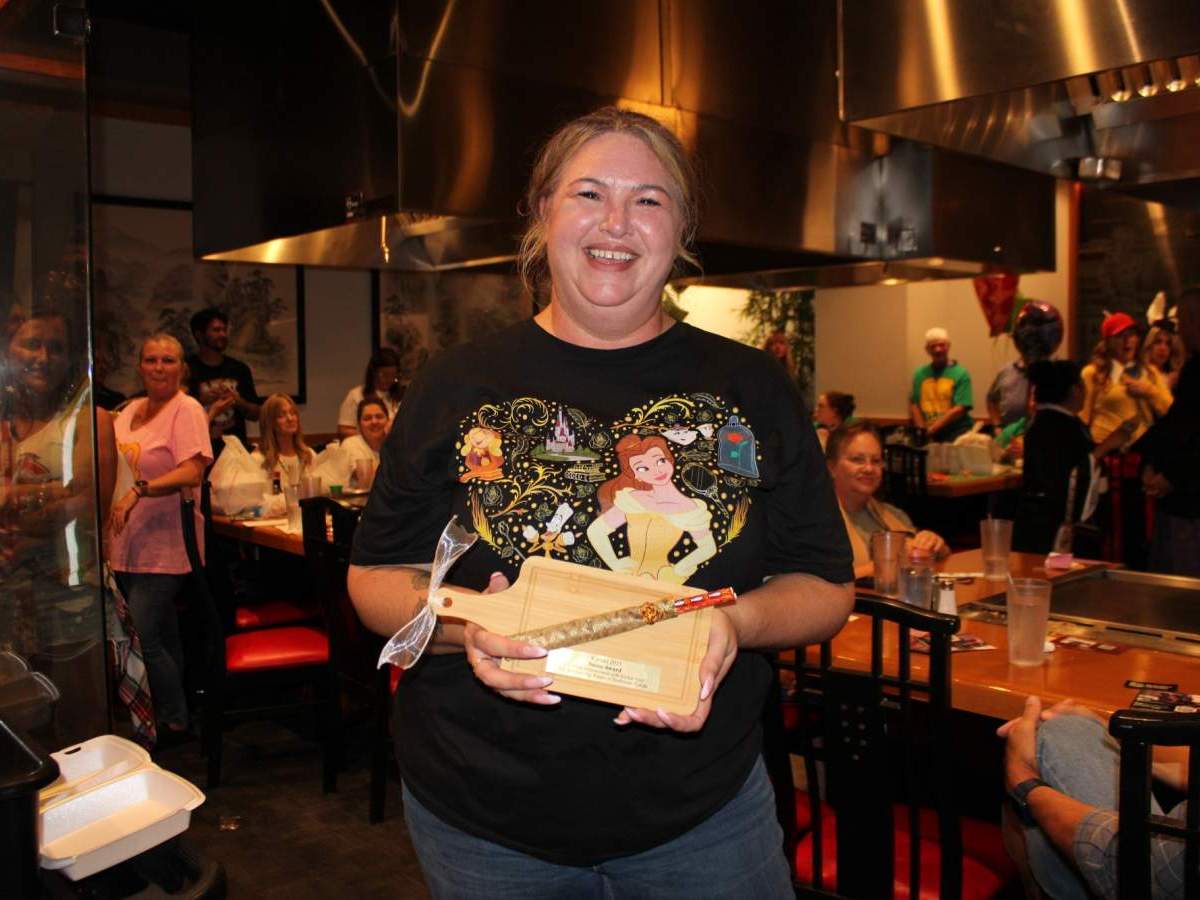 Another Person holding custom cutting board and chopsticks