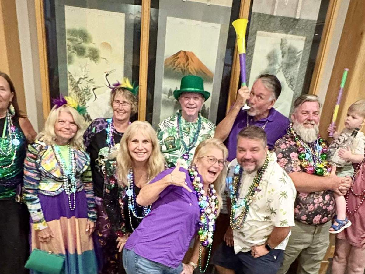 Group in Mardi Gras attire posing for photo